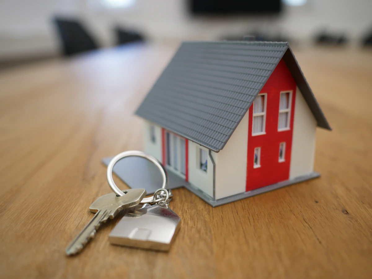 Real estate agent reviewing documents and house keys with clients at home closing